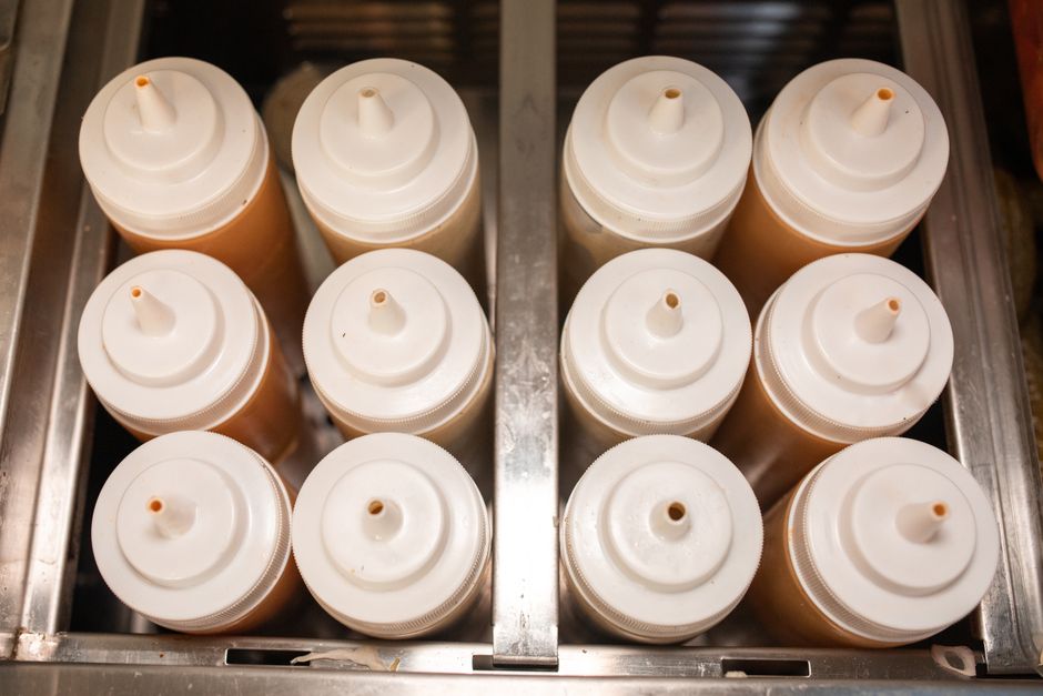 Top-down view of condiment bottles in a steel holder, perfect for kitchens.